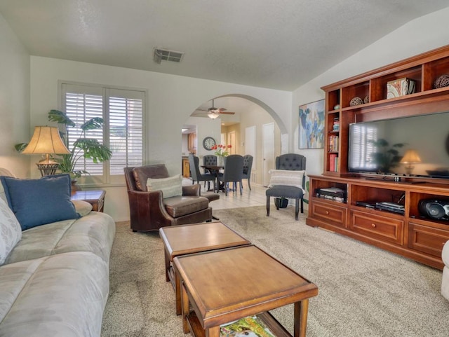 living room with vaulted ceiling, ceiling fan, and carpet flooring