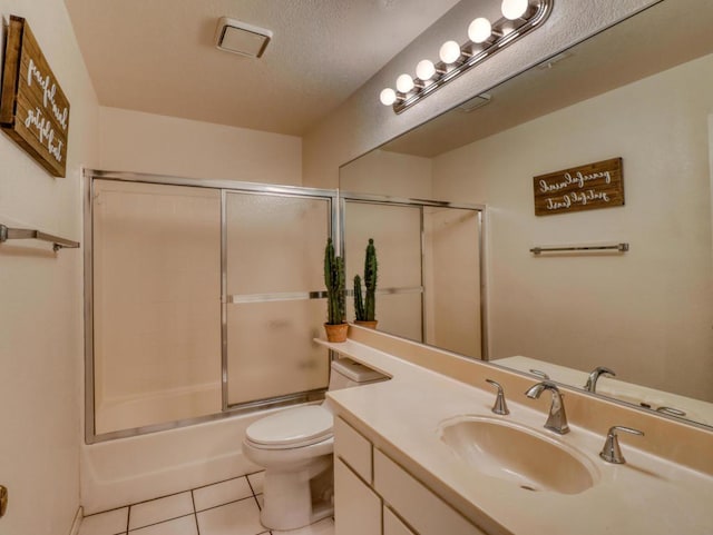 full bathroom with toilet, vanity, tile patterned floors, enclosed tub / shower combo, and a textured ceiling