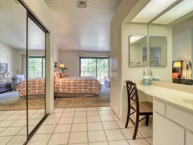 carpeted bedroom featuring a textured ceiling and sink