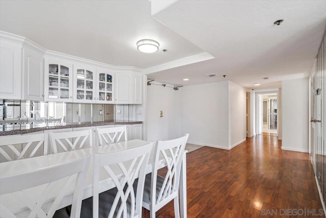 kitchen with white cabinets, dark hardwood / wood-style floors, and kitchen peninsula