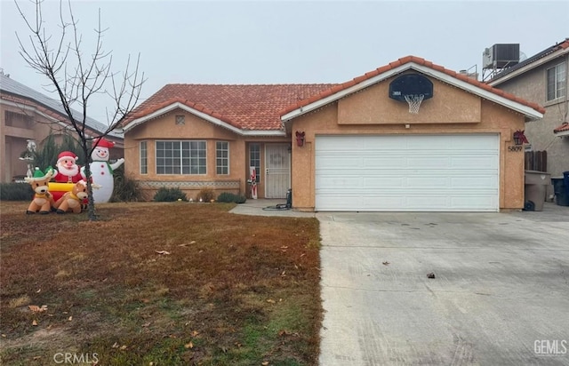 ranch-style house featuring cooling unit and a garage