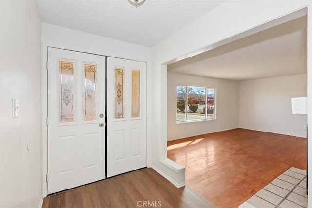 foyer entrance with hardwood / wood-style flooring and a textured ceiling