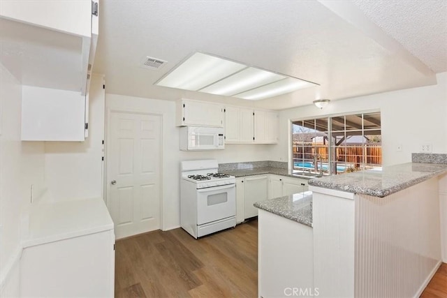 kitchen with sink, white appliances, light hardwood / wood-style flooring, white cabinets, and kitchen peninsula