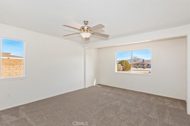 carpeted spare room with ceiling fan and a textured ceiling