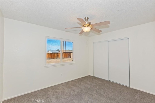 unfurnished bedroom featuring ceiling fan, a closet, carpet, and a textured ceiling