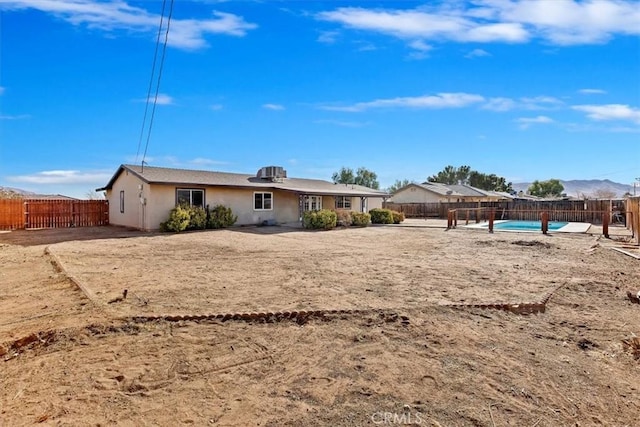 rear view of property with a fenced in pool