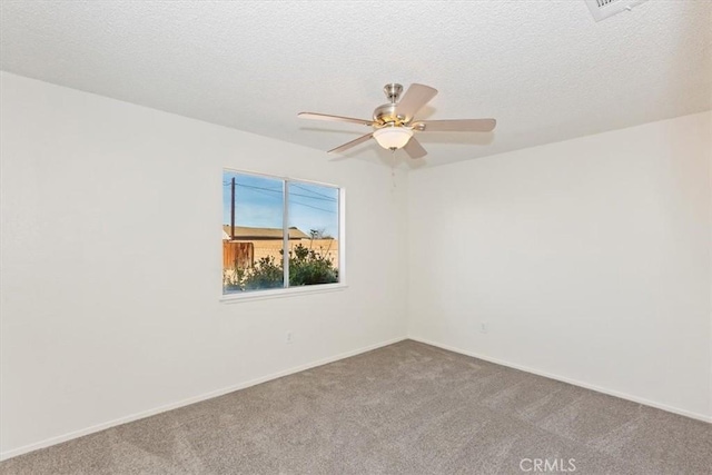 carpeted empty room featuring ceiling fan and a textured ceiling