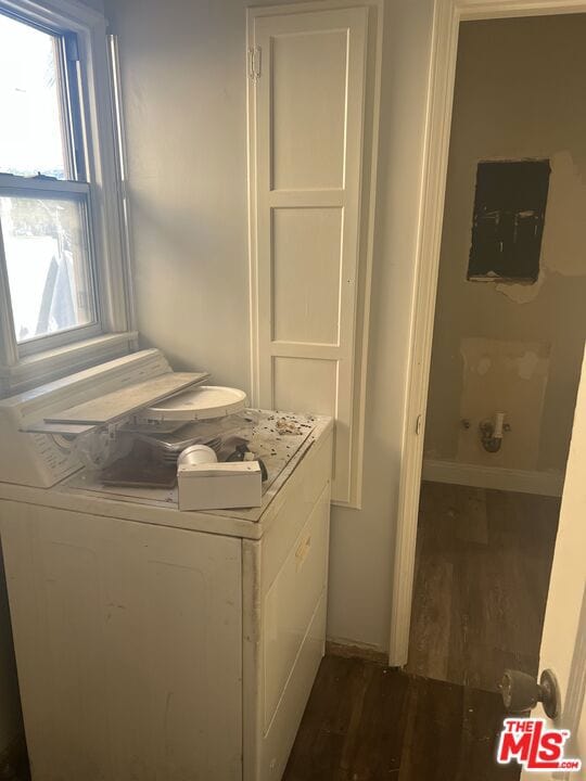 washroom with dark hardwood / wood-style flooring, washer / clothes dryer, and electric panel