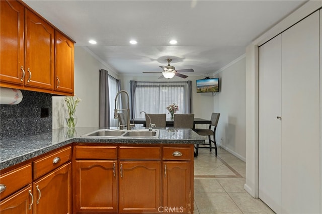 kitchen featuring sink, backsplash, ornamental molding, kitchen peninsula, and light tile patterned floors