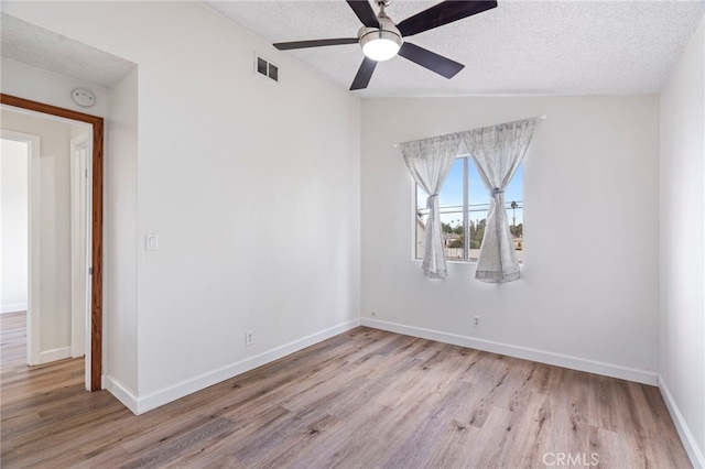 unfurnished room with a textured ceiling, ceiling fan, lofted ceiling, and light hardwood / wood-style flooring