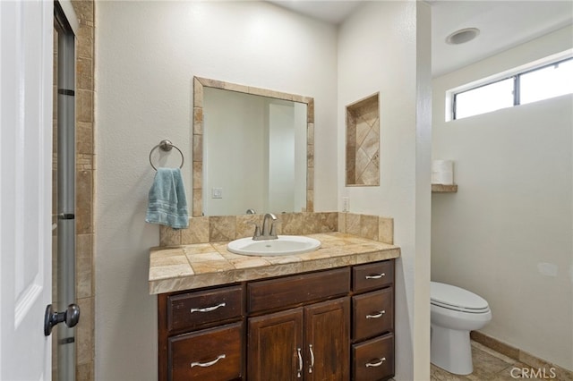 bathroom featuring toilet, vanity, and tile patterned flooring