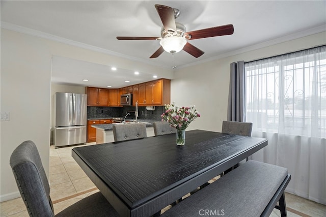 tiled dining area with ceiling fan and ornamental molding