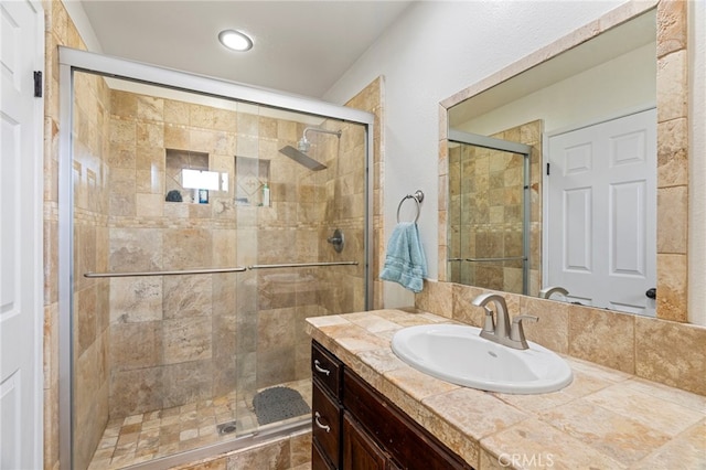 bathroom featuring vanity and a shower with door