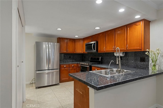 kitchen featuring light tile patterned floors, kitchen peninsula, appliances with stainless steel finishes, tasteful backsplash, and dark stone counters