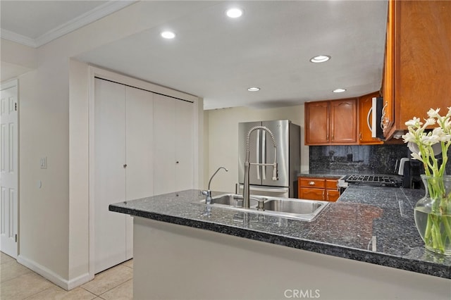 kitchen featuring kitchen peninsula, decorative backsplash, light tile patterned flooring, crown molding, and appliances with stainless steel finishes