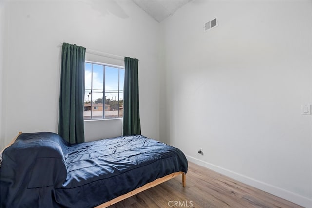 bedroom with lofted ceiling and hardwood / wood-style floors