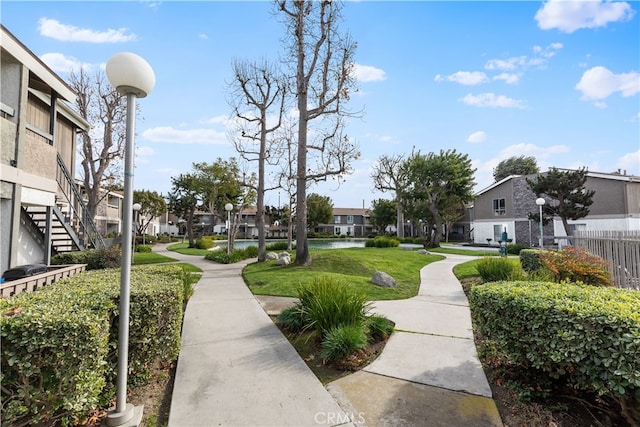 view of home's community featuring a water view and a lawn