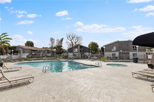 view of swimming pool featuring a hot tub and a patio