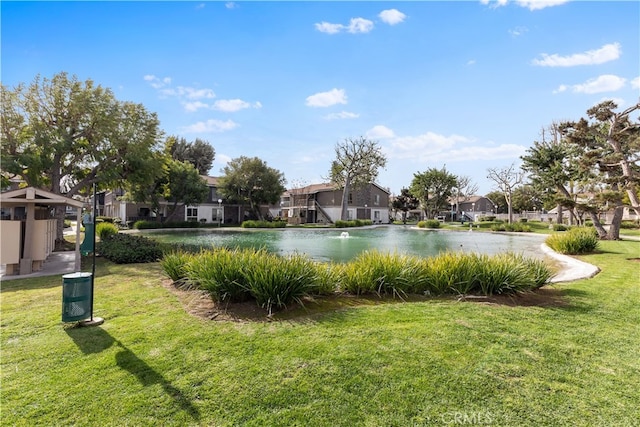 view of pool with a water view and a yard