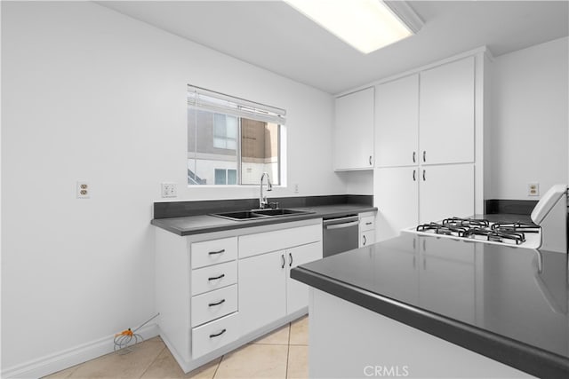 kitchen with stainless steel dishwasher, sink, white cabinetry, and light tile patterned flooring