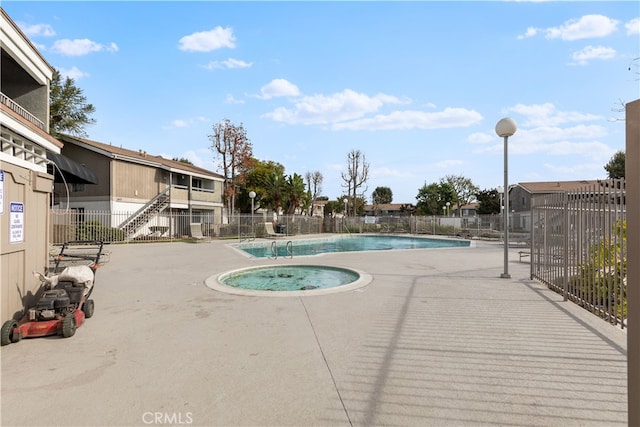 view of pool featuring a patio area and a hot tub