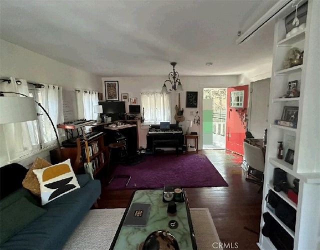 living room featuring built in shelves, dark wood-type flooring, and a notable chandelier