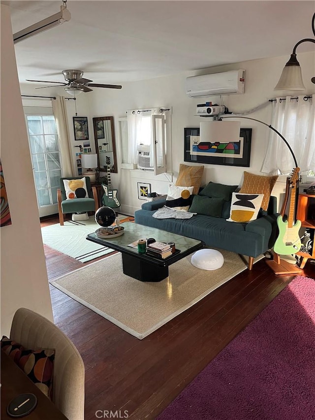 living room with ceiling fan, cooling unit, hardwood / wood-style flooring, and a wall mounted air conditioner