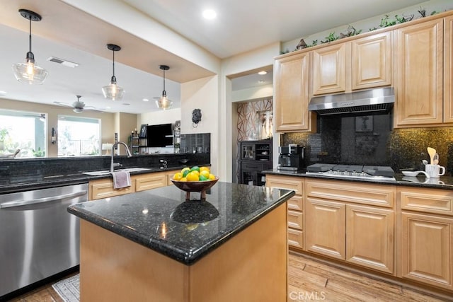 kitchen with stainless steel dishwasher, white gas stovetop, ventilation hood, dark stone countertops, and a center island