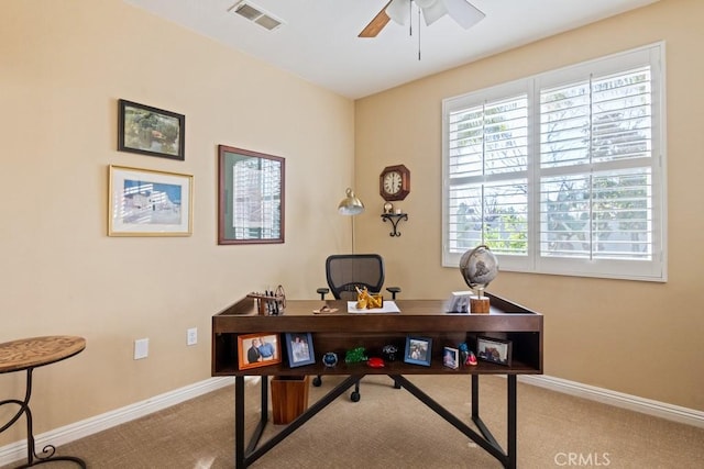 carpeted home office featuring ceiling fan