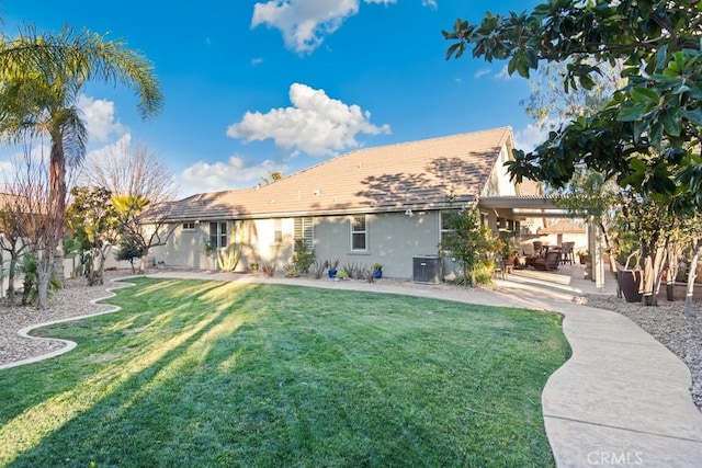 back of property featuring central AC, a patio area, and a lawn