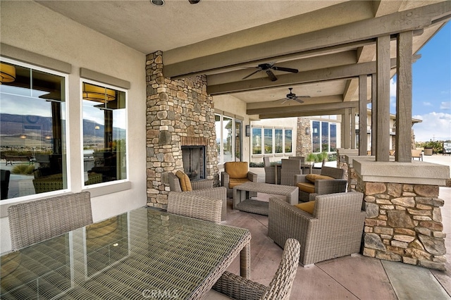 view of patio / terrace with an outdoor living space with a fireplace and ceiling fan