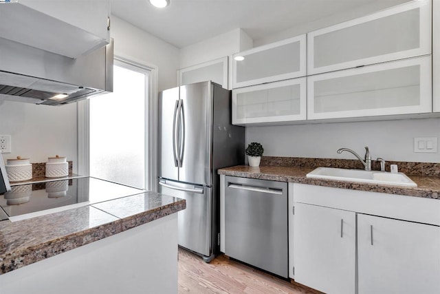 kitchen featuring white cabinets, appliances with stainless steel finishes, sink, and light hardwood / wood-style flooring