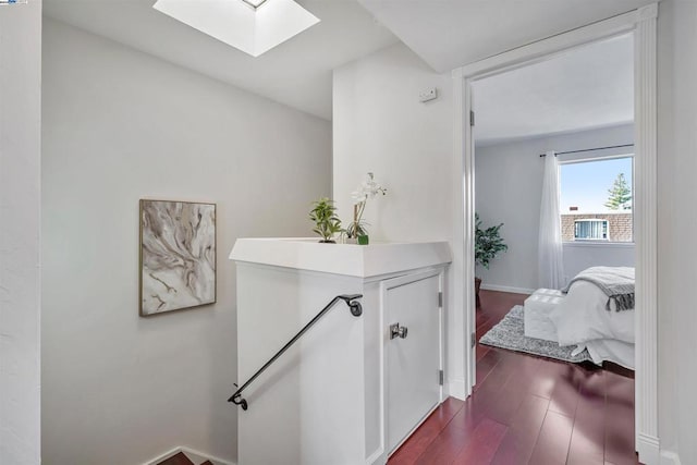 hall with a skylight and wood-type flooring