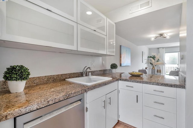 kitchen featuring white cabinetry, dishwasher, and sink