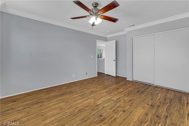 unfurnished bedroom featuring ceiling fan, wood-type flooring, a closet, and ornamental molding