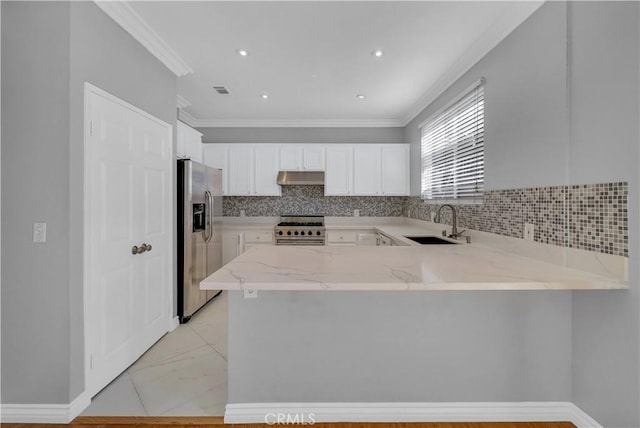 kitchen with sink, white cabinets, appliances with stainless steel finishes, and kitchen peninsula