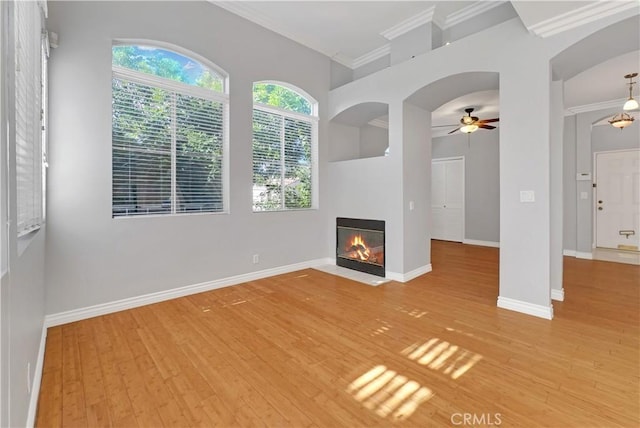 unfurnished living room featuring ceiling fan, light hardwood / wood-style floors, and crown molding