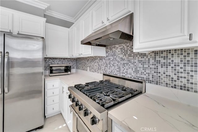 kitchen featuring tasteful backsplash, light stone counters, stainless steel appliances, and white cabinetry