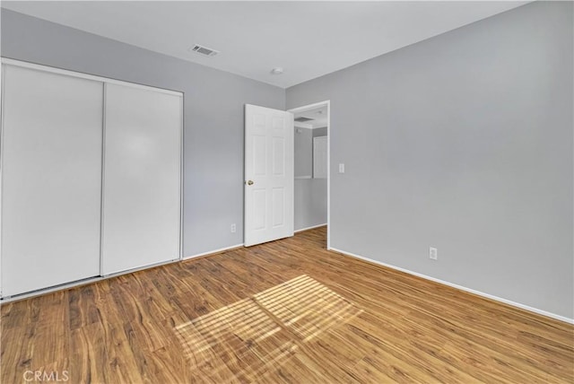 unfurnished bedroom with a closet and hardwood / wood-style flooring