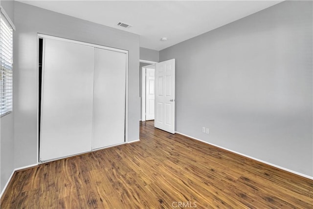 unfurnished bedroom with hardwood / wood-style floors and a closet