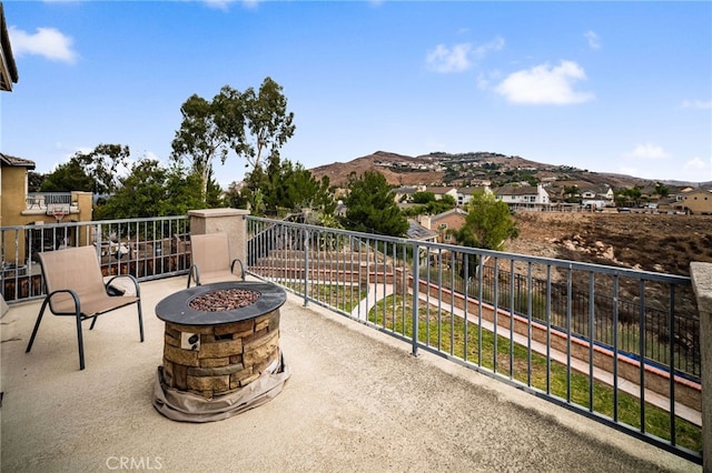 balcony featuring a mountain view and an outdoor fire pit