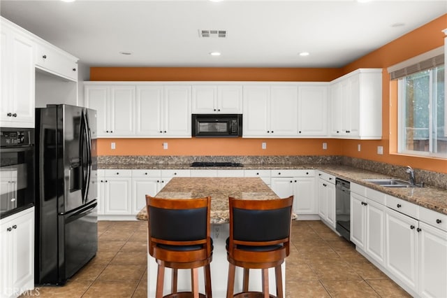 kitchen featuring sink, white cabinetry, black appliances, and a kitchen island