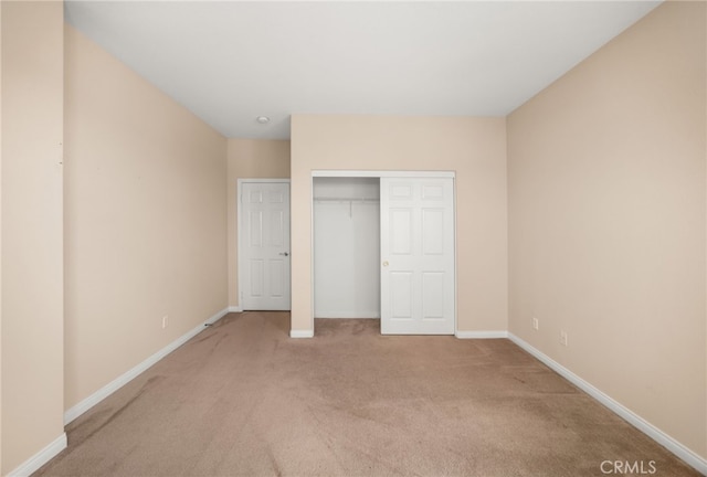 unfurnished bedroom with a closet and light carpet