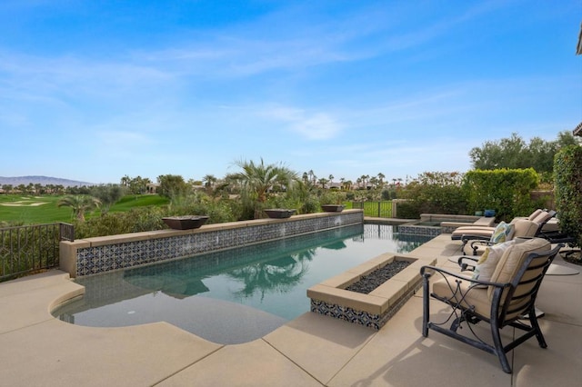 view of pool with a patio area, an outdoor fire pit, and an in ground hot tub