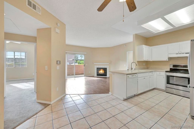 kitchen featuring appliances with stainless steel finishes, white cabinetry, sink, ceiling fan, and light colored carpet