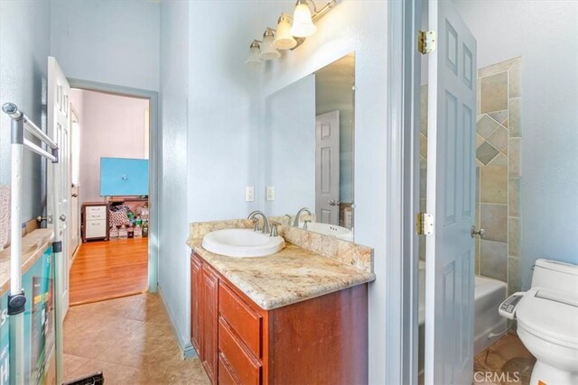 bathroom with toilet, tile patterned floors, and vanity