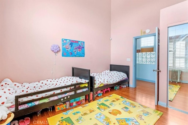 bedroom with hardwood / wood-style flooring and radiator heating unit