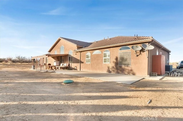 rear view of house featuring a patio area and central AC unit