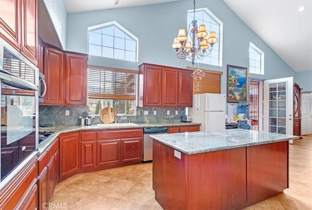 kitchen with white fridge, dishwasher, tasteful backsplash, and a notable chandelier