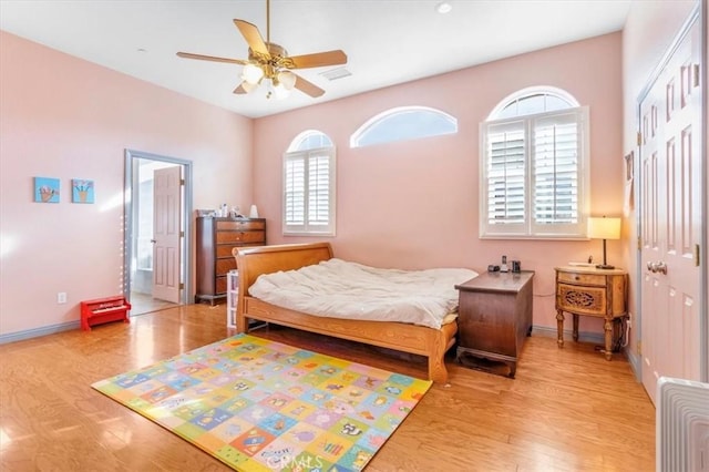 bedroom featuring ceiling fan, light wood-type flooring, a closet, and multiple windows